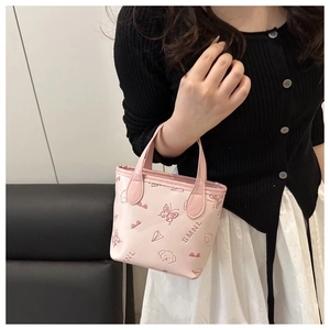 Detailed macro view of pink embossed mini tote bag with butterfly and puppy patterns