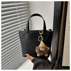 Detailed macro view of embossed leather texture with SMNL logo and cute plush charm