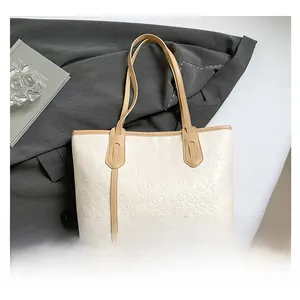 Detail of cartoon embossed beige tote bag with stylish khaki leather trim and large capacity