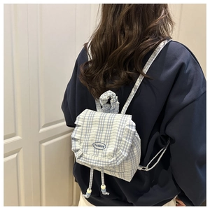 Detail view of the fashion embroidery and ruffled lace on blue checkered backpack