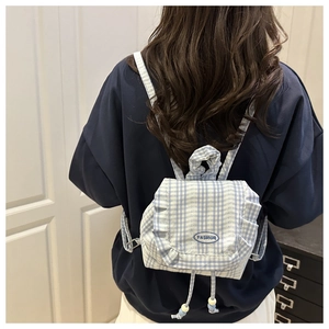 Detail of blue plaid lace mini backpack with ruffle edges and fashion label on the back