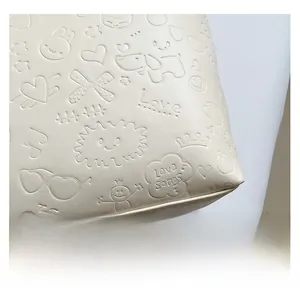 Close-up of creamy white embossed leather with cute animal and heart pattern details