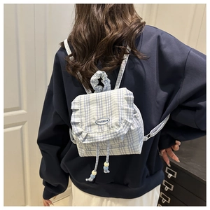 Detail of blue plaid mini backpack featuring ruffled lace edges and fashion embroidery