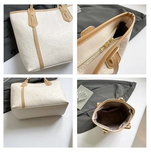 Close-up of white embossed leather tote showing zip closure and internal storage pocket