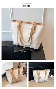 Detail of white tote bag with khaki handles and embossed cartoon pattern textures