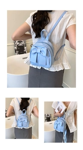 Detail showing back view of light blue mini backpack with bow knot on a model