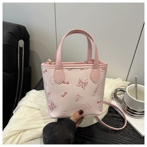 Detail view of pink mini bucket bag featuring embossed butterflies and slender shoulder strap