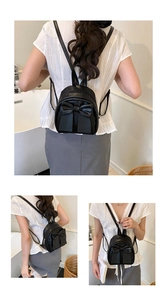 Detail of a mini black leather backpack featuring a large bow and adjustable straps