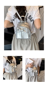 Detail of silver bow mini backpack with metallic PU texture and metal zipper