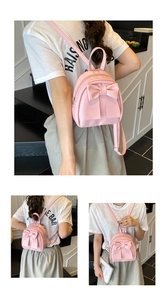 Detail of a pink mini backpack with a large bow decoration and adjustable thin straps