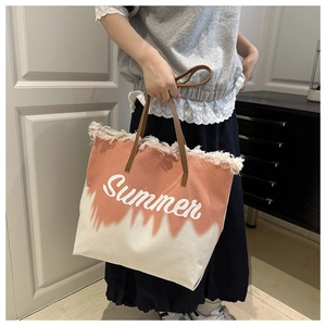 Detail van roze tie-dye canvas tas met Summer-opdruk en bruine lederen handvatten