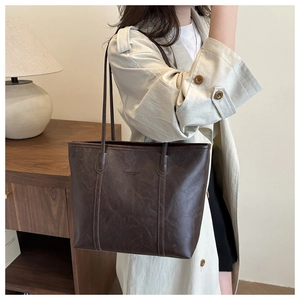 Dettaglio borsa tote vintage marrone scuro con trama cerata e spalline lunghe sottili