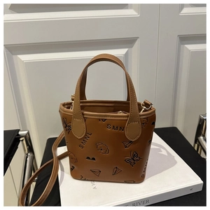 Detail of small brown embossed handbag with SMNL pattern and crossbody strap