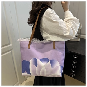Dettaglio della borsa tote in tela viola con stampa floreale e bordo sfrangiato