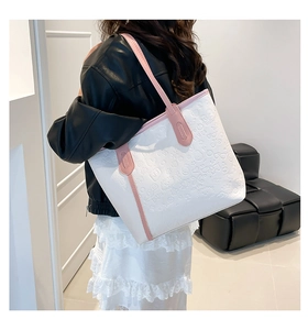 Detail of pink and white tote bag featuring cartoon embossed patterns and reinforced handles