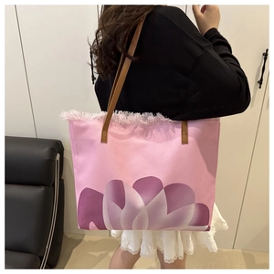 Vista dettagliata di una borsa tote rosa stampata con bordo a frange e fiori chic.