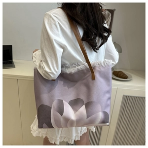 Detalle de flecos deshilachados y estampado floral degradado en bolso tote violeta