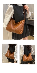 Detailansicht der braunen Vintage Hobo-Tasche mit silbernen Nieten-M und langem Gurt
