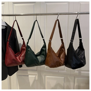 Detailansicht großer Retro-Hobo-Taschen in vier Farben mit Nietendesign an der Seite