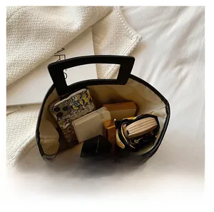 Vue de dessus de l'intérieur du fourre-tout noir montrant l'espace pour téléphone et maquillage