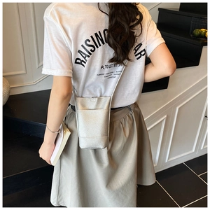 Silver lychee grain leather mini crossbody bag shown with a slim chain strap on a model