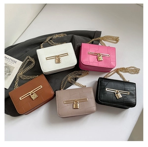Detail of five croc-effect flap bags in varied colors with gold chain and padlock hardware