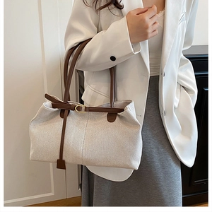 Detail of vintage beige tweed tote bag with dark brown leather straps and gold buckle