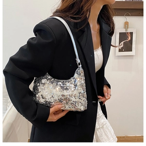 Close-up of a silver sequin shoulder bag showing shimmering metallic texture and slim strap