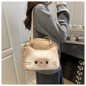 Detail of cute cat embroidery on beige plush and PU leather crossbody bag worn by a model