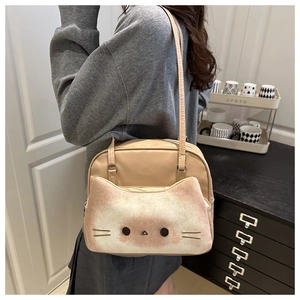 Détail du patchwork chat en peluche sur un sac bandoulière beige en similicuir porté