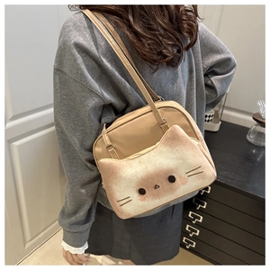 Detail of khaki cartoon cat shoulder bag shown on model with creative cat face pocket design