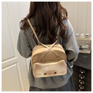 Détail de la poche chat sur un sac à dos beige en similicuir porté par un modèle