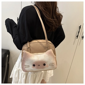 Détail du sac beige avec une poche chat en peluche et une bandoulière en cuir
