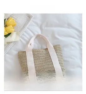 Detail of woven straw tote bag with wavy texture and durable white canvas handles