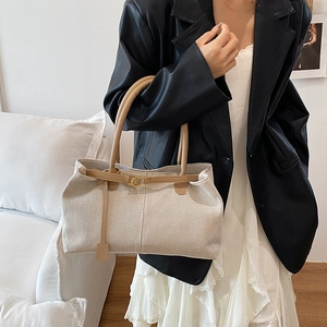 Chic beige canvas tote bag with brown leather straps for elegant daily commuting style