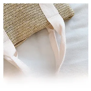 Macro detail of natural straw woven pattern and durable off-white canvas handle