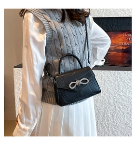 Détail du sac à main noir motif pierre avec boucle noeud strass et poignée fixe