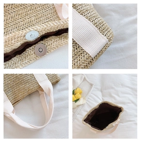 Detail view of woven straw tote bag showing silver magnetic closure and sturdy canvas straps