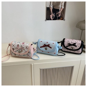 Detailed close-up of three mini crossbody bags with bowknots and cute floral patterns