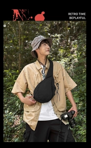 Close-up of black crossbody chest bag with side mesh pocket during an outdoor hike