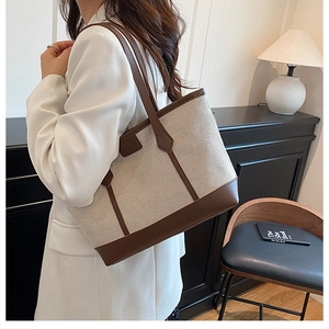 Détail d'un cabas en toile et cuir porté avec un blazer blanc pour un look de bureau
