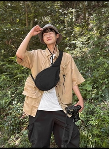 Outdoor lifestyle view of a black crescent nylon chest bag styled with urban cargo outfit