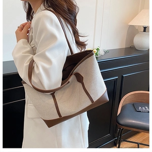 Lifestyle view of large beige canvas tote bag with brown leather trim and contrast stitching