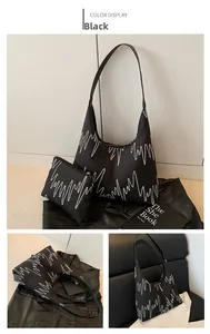 Detail of black tote bag featuring colorful wavy embroidery and matching pouch set
