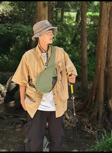 Outdoor olive crossbody chest bag and khaki utility shirt styling in forest setting