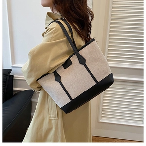 Vue latérale d'un grand sac cabas en toile et cuir porté avec un trench-coat kaki
