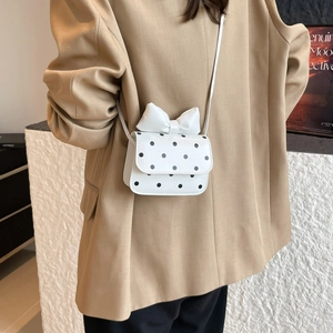 Chic white leather shoulder bag with black polka dots and decorative bow detail