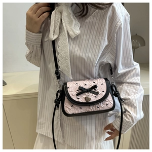 Detail of pink pleated crossbody bag with black bow prints and heart metal charm decoration