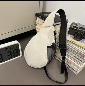 Detail of off-white crossbody sling bag with breathable side mesh pocket and wide strap