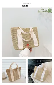 Detail of woven straw tote bag with white ribbon handles and V-shaped knit texture